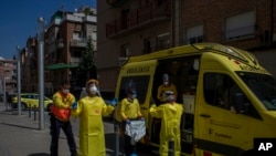 Health personnel wearing protection gear to protect against the spread of the new coronavirus prepare to attend to a patient during the COVID-19 virus outbreak in Barcelona, Spain, April 6, 2020.