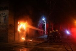 Firemen work to put out flames from a building during an anti-government protest in Santiago, Chile, Oct. 28, 2019.