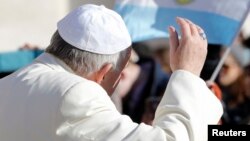 Le pape François salue de la main lors d'une audience à la place St Pierre, Vatican, 18 février 2015.