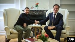 18일 벨기에 브뤼셀에서 열린 EU-서발칸 정상회담 중 마르크 뤼터 북대서양조약기구 사무총장과 볼로디미르 젤렌스키 우크라이나 대통령이 만나 악수를 나누고 있다.