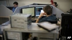 FILE - Employees of Moscow’s Group-IB, which is responsible for one of Russia’s two official internet watchdogs, work in their laboratory in Moscow, Russia, May 30, 2013.