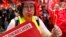 A supporter of the Confederation of German Trade Unions (DGB) blows a whistle as she takes part in a union rally for "political change" in Frankfurt, Sept. 7, 2013. 