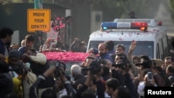 Supporters sprinkle rose petals on a car carrying former Prime Minister Nawaz Sharif, as he makes his way to the airport to travel for a medical treatment in London, outside his residence in Raiwind, near Lahore, Pakistan Nov. 19, 2019.