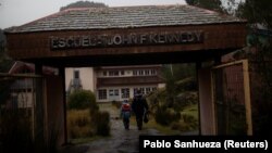 Carlos Guerrero, 40, with his son Diego, 7, arrive at John F Kennedy School in the village of Sotomo, outside the town of Cochamo, Los Lagos region, Chile, August 6, 2021. (REUTERS/Pablo Sanhueza)