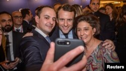 Emmanuel Macron, center, candidate for the 2017 French presidential election, poses for a selfie with guests during the annual dinner of the Representative Council of France's Jewish Associations in Paris, Feb. 22, 2017. 