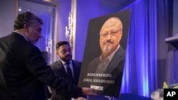 Mongi Dhaouadi (kiri) dan Ahmed Bedier mempersiapkan gambar wartawan Saudi yang terbunuh, Jamal Khashoggi, sebelum sebuah acara untuk mengenang Khashoggi, seorang kolomnis untuk The Washington Post yang terbunuh tanggal 2 Oktober di dalam komplek Konsulat Saudi di Istanbul, Washi