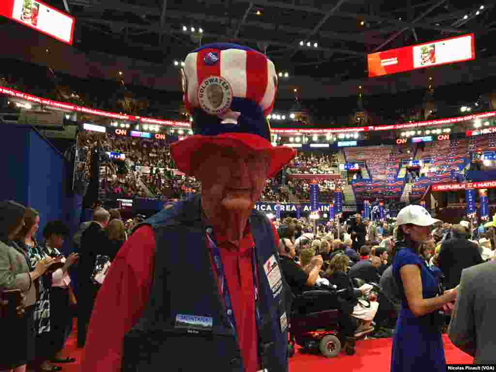 Couvert d&#39;un chapeau rappelant l&#39;oncle Sam, un participant affiche des insignes de l&rsquo;état de Montana et de l&rsquo;ancien président Bush à Cleveland, Ohio, le 18 juillet 2016. (VOA/Nicolas Pinault).