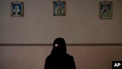 FILE - Khadija Abd poses for a portrait in her family's house in Mosul, Iraq, Apr. 14, 2019. On a chilly January evening, the Abd family had just finished supper at their farm when the two men with guns burst into the room.