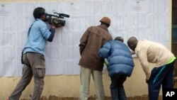 A television cameraman films Kenyans checking if their names are on the electoral lists at a polling station in the Kibera slum in Nairobi, Kenya, Aug. 7, 2017. Kenyans are due to go to the polls on Aug. 8, to vote in presidential elections after a tightly-fought race between President Uhuru Kenyatta and main opposition leader Raila Odinga.