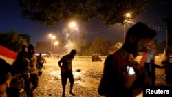 Demonstrators run away from tear gas fired by Iraqi security forces during a protest over corruption, lack of jobs and poor services, in Baghdad, Iraq, Oct. 26, 2019.