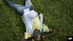 A supporter of opposition candidate Julius Maada Bio naps under stadium lights at rally, Freetown, Sierra Leone, Nov. 15, 2012.