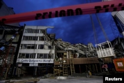 The remains of a building that collapsed in an earthquake and red tape reading "Danger" are seen after rescue teams retrieved the last body trapped in the rubble, in Mexico City, Mexico, Oct. 4, 2017.