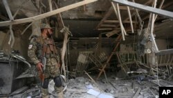 Penjaga keamanan Afghanistan berdiri di dalam bank pasca insiden bom bunuh diri di Kabul, Afghanistan, Selasa, 29 Agustus 2017. (AP Photo / Rahmat Gul)