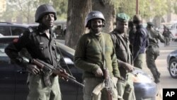 Des policiers nigérians montant la garde à Kano, Nigéria, après un attentat de Boko Haram (22 jan. 2012)