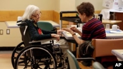 In this 2015 photo, Tamara Rusoff-Hoen talks with her mother, Louise Irving, at The Hebrew Home of Riverdale in New York City. The nursing home has a program in which relatives record video messages for patients of Alzheimer's and other form of dementia. (AP Photo/Richard Drew)