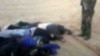 In this image from video posted on an Islamist web site, an armed man appears to stand over the what are claimed to be the corpses of some of the seven foreign hostages abducted from northern Nigeria and later killed by Islamic extremists, Mar. 3, 2013.. 