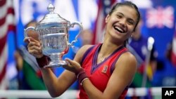 នាង Emma Raducanu កាន់​ពាន​រង្វាន់​ប្រកួតកីឡា​វាយតេនីស US Open ក្រោយ​យក​ឈ្នះ​នាង Leylah Fernandez នៅ​ទីក្រុង​ញូវយ៉ក ថ្ងៃទី១១ ខែកញ្ញា ឆ្នាំ២០២១។ (AP Photo/Seth Wenig)