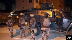 Turkish anti-terrorism police stand by their armoured vehicle during an operation to arrest people over alleged links to the Islamic State group, in Adiyaman, southeastern Turkey, early Sunday, Feb. 5, 2017. 