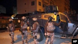 Turkish anti-terrorism police stand by their armoured vehicle during an operation to arrest people over alleged links to the so-called Islamic State group, in Adiyaman, southeastern Turkey, early Sunday, Feb. 5, 2017. 