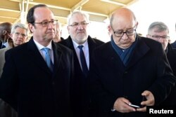 French President Francois Hollande (L) and French Minister for Defence Jean-Yves Le Drian (R) visit French Forces at the Air Force Base 118 in Mont-de-Marsan, France, Jan. 6, 2017.