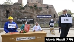 Aktivis Amnesty International, Emergency dan Oxfam menggelar demonstrasi flashmob untuk mengecam situasi ketimpangan akses vaksin di dunia, pada 29 Oktober 2021 di Piazza Vittorio di Roma menjelang KTT Pemimpin Dunia G20. (Foto: Alberto Pizzoli/AFP)