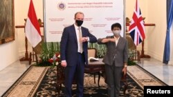 Menteri Luar Negeri Inggris Dominic Raab (kiri) melakukan "salam siku" dengan Menlu RI Retno Marsudi usai melakukan konferensi pers di Jakarta, hari Rabu (7/4).