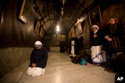 A nun prays inside the Grotto at the Church of the Nativity, traditionally believed by Christians to be the birthplace of Jesus Christ, in the West Bank city of Bethlehem on Christmas Eve, Thursday, Dec. 24, 2015.