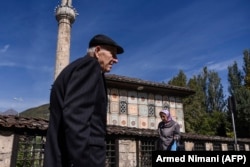 MACEDONIA -- Albanians walk past a mosque in the town of Tetovo, near Skopje, on September 28, 2018, ahead of a referendum on whether to change the country's name to "Republic of Northern Macedonia".