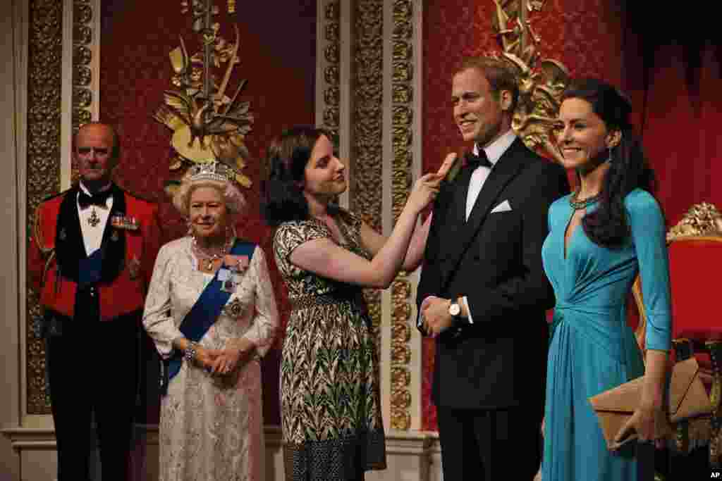 Seorang pekerja museum Madame Tussauds merapikan patung lilin Pangeran William dan isterinya, Kate Middleton (Duchess of Cambridge) di London.
