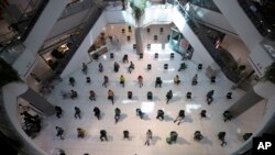 People practice social distancing as they sit on chairs spread apart in a waiting area for take-away food orders at a shopping mall in hopes of preventing the spread of the coronavirus in Bangkok, Thailand, March 24, 2020.