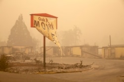 The melted sign of the Oak Park Motel destroyed by the flames of the Beachie Creek Fire is seen in Gates, east of Salem, Oregon on September 13, 2020.