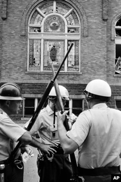 Policeman stand guard outside the 16th Street Baptist Church in Birmingham, Ala., which was the scene of an explosion that killed four African American children, Sept. 15, 1963.