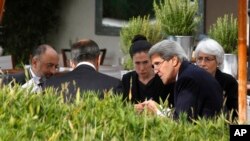FILE - U.S. Secretary of State John Kerry, second right, and Russian Foreign Minister Sergei Lavrov, back to camera, talk, with their senior aides at a hotel in Geneva, Switzerland, Sept. 14, 2013. For their meetings this weekend on Syria, they will be joined by officials from the Middle East.