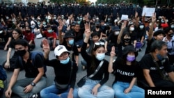 Pro-democracy demonstrators flash a three-finger salute while sitting on the ground during a Thai anti-government mass protest, on the 47th anniversary of the 1973 student uprising, in Bangkok, Thailand October 14, 2020. REUTERS/Soe Zeya Tun