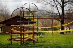 Playground equipment is wrapped in crime scene tape to prevent its use as part of the effort to slow the spread of the coronavirus March 31, 2020, in St. Louis, MIssouri.