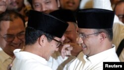Anies Baswedan dan Sandiago Uno berbincang setelah perhitungan suara pemilihan Gubernur DKI Jakarta. (REUTERS/Beawiharta)