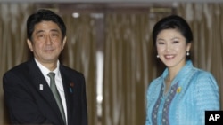 日本首相安倍晋三和泰国总理英拉1月17日在曼谷举行联合记者后合影。
