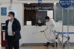 A worker sprays disinfectant as a precaution against the new coronavirus at the Seoul Railway Station in Seoul, South Korea, March 29, 2020.