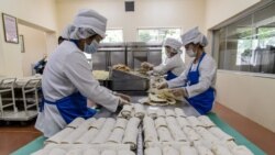 Employees produce wheat cakes stuffed with meat at the Kumsong Foodstuff Factory in Pyongyang on Sept. 24, 2021.