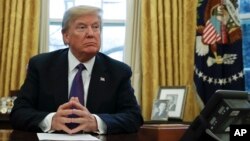 President Donald Trump prepares to sign Section 201 actions in the Oval Office of the White House in Washington, Jan. 23, 2018. 