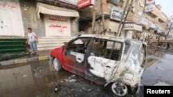 FILE - A man stands by a car damaged by a strike near al-Thawra Hospital in Hodeidah, Yemen, Aug. 2, 2018.