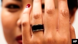 A woman shows a prototype of the Mota Smart Ring at the consumer electronic fair IFA in Berlin, Germany, Sept. 5, 2014. The smart ring is designed to notify users about incoming messages and phone calls, something, experts say, can be used to cheat.