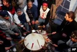 Members of the Mashpee Wampanoag tribe play a drum waiting for news that the tribe has won recognition as a sovereign American Indian nation, Feb 15, 2007, in Mashpee, Mass.