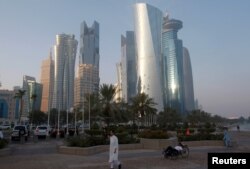 FILE - A man walks on the corniche in Doha, Qatar, June 15, 2017.