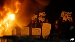 Protesters watch a fire on Sproul Plaza during a rally against the scheduled speaking appearance by Breitbart News editor Milo Yiannopoulos on the University of California at Berkeley campus, Feb. 1, 2017, in Berkeley, Calif.