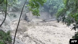 An image taken from video on Oct. 5, 2023, shows a damaged steel bridge over the flooded Teesta River in north Sikkim's Chungthang region of India. The death toll from a glacial lake burst that triggered a torrential flash flood has risen to at least 47 people. (Indian Army/AFP)