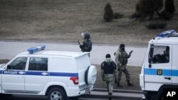 Police officers stand ready to prevent a rally commemorating the founding of Belarus' 1918 proclamation of independence from Russia, in Minsk, Belarus, Thursday, March 25, 2021.