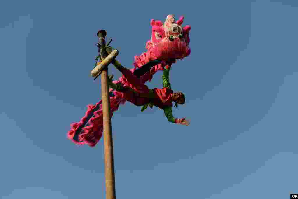 Seorang pria melakukan atraksi di atas panggung demonstran anti pemerintah di dekat kawasan bisnis di ibukota Bangkok, Thailand.