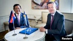 FILE PHOTO - Cambodian Deputy Prime Minister and Interior Minister Sar Kheng and Swedish Minister of the Interior Anders Ygeman smile after signing a cooperation agreement between the two countries in Stockholm, Sweden, May 25, 2015. (REUTERS)