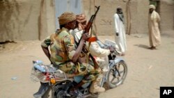 Des soldats tchdiennes patrouillent sur une moto dans le village de N'Gouboua, jeudi 5 mars 2015. 
